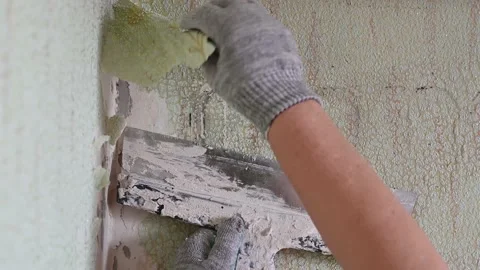 Scraping old wallpaper from the wall with spatulas and improvised means Stock Footage 168713785