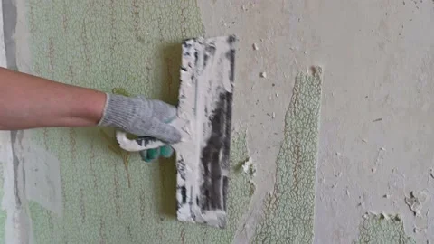 Scraping old wallpaper from the wall with spatulas and improvised means Stock Footage 168713813