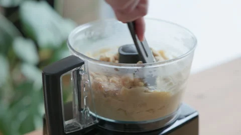 Scraping the Sides of a Food Processor Bowl to Ensure Smooth Hummus Consistency. Stock Footage 326642387