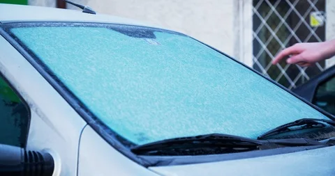 Scraping smiley on frozen windshield Stockbeeldmateriaal 104984285