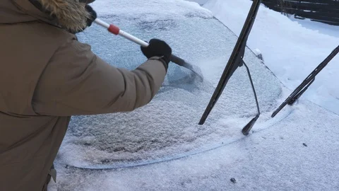 Scraping snow and ice from car windshield. Winter driving. Toronto, Canada. Stock Footage