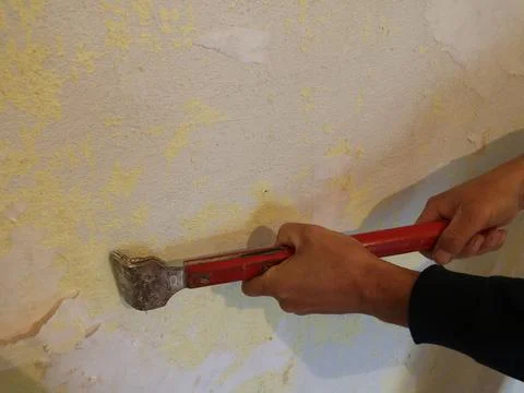 Scraping wallpaper off the wall Stock Photos