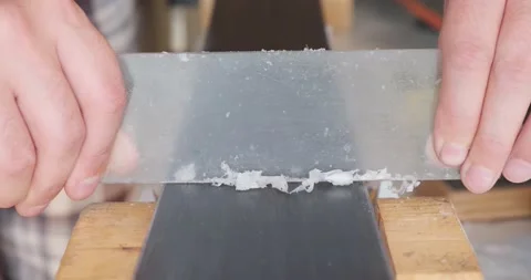 Scraping wax from ski base with plastic scraper. Ski tuning, maintenance at home Video stock 140211377