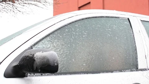 Scrapping ice glazed car windows after blizzard Stock Footage 99372717