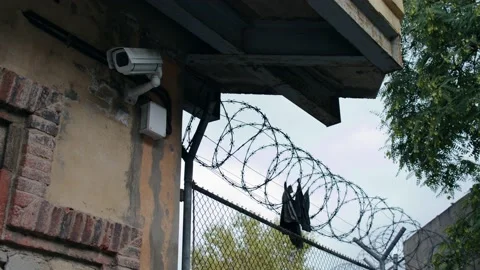 Scraps of prisoner robe on the barbed wire of the prison Stock Footage 165052489