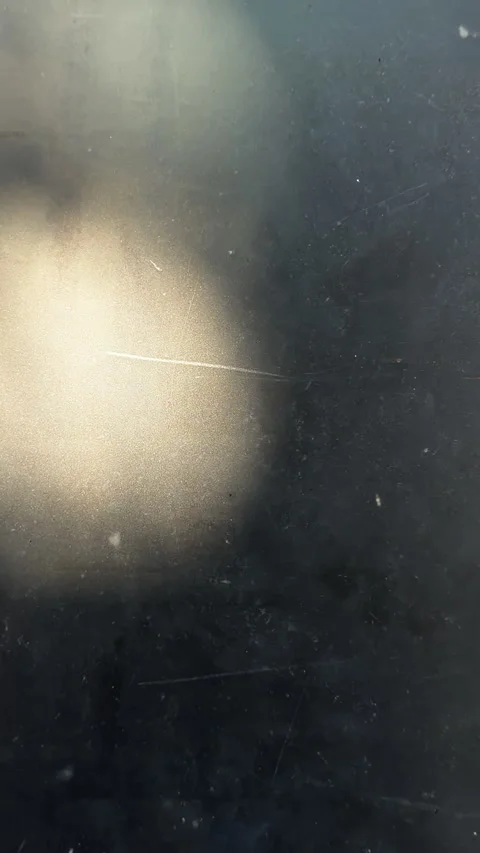 Scratched dark surface with warm golden light orb Stock Footage 336814856