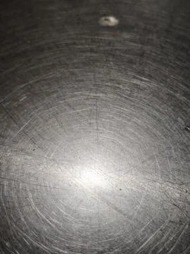 Scratches and circular swirl patterns on a worn stainless steel table top c.. Stock Photos