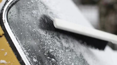 Scratching ice and cleaning snow from a vintage car windshield Stock Footage 147171793