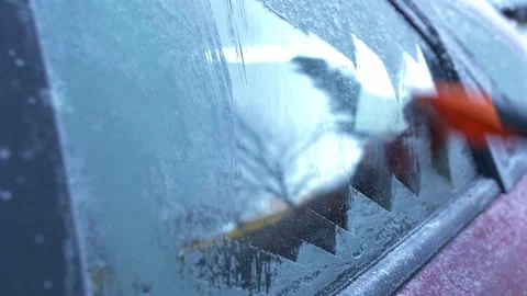 Scratching Ice from Frozen Car Window with Orange Ice Scraper Stock Footage 146574071