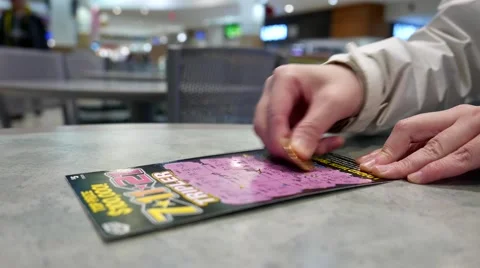 Scratching lottery ticket inside shopping mall food court area Video stock 64952086
