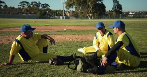 Scratching nose three men teammates prompting discussion on baseball infield Stock Footage 342018098