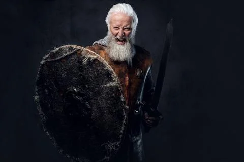 Screaming elderly warrior with shield and sword dressed in armor Stockfoto's