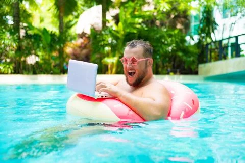 Screaming Funny fat male in pink glasses on an inflatable circle in the pool Stock Photos