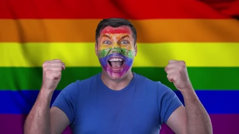 A screaming man with a face painted in the color of the LGBT flag. Stock Footage 146906341