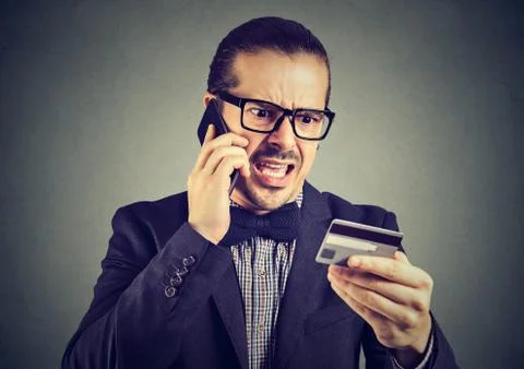 Screaming man solving problems with credit card 写真素材