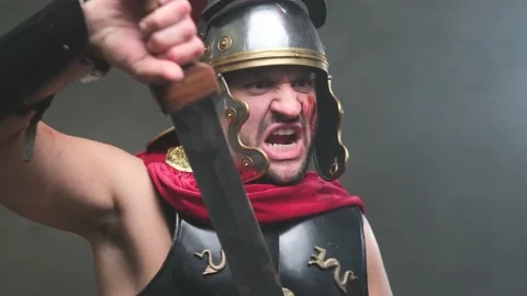 Screaming violent roman soldier pulls out his sword and points it Stock Footage 146522640