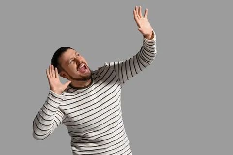 Screaming young man on grey background Stock Photos