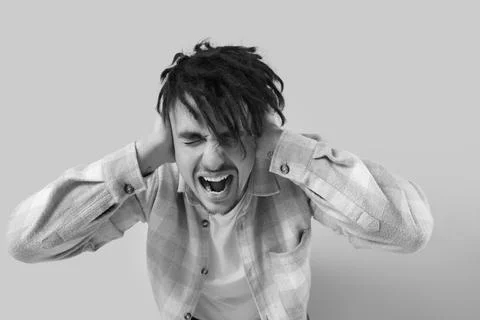 Screaming young man having panic attack on light background Stock Photos
