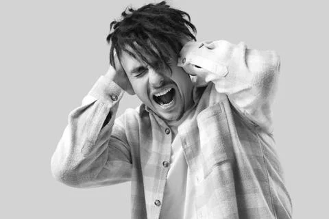 Screaming young man having panic attack on light background Stock Photos