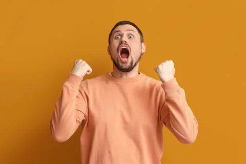 Screaming young man on orange background Stock Photos