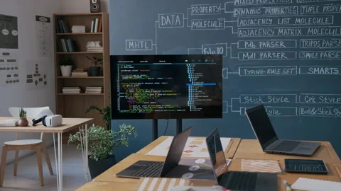 Screen with Computer Code and Laptops on Desks in Programming Class Stock Footage 306933738
