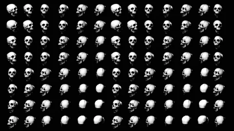 Screen filled with over a hundred rotating skulls in black background. Slow r Stock Footage 156383045