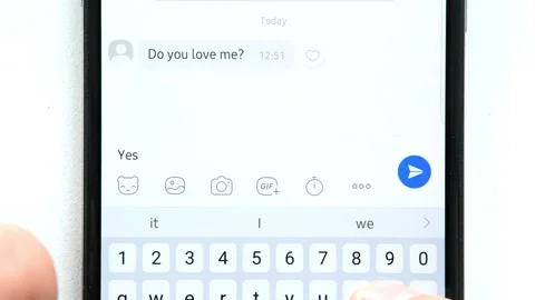 On screen of mobile phone, message from interlocutor "Do you love me?" comes and Stock Footage 248028781