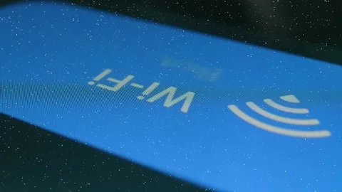 On the screen of a modern smartphone a finger presses the Wi-Fi on, off icon Video stock 330894688