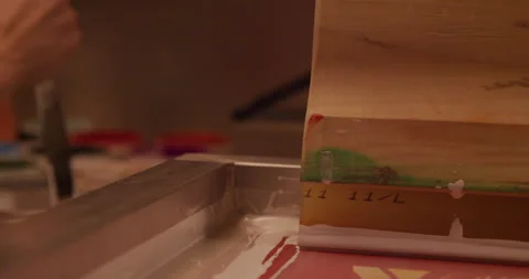 Screen printer stirs and mixes ink for tee shirt printing Stock Footage 248324518