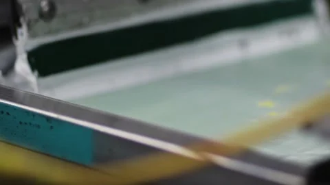 Screen printing silk screen with squeegee applying white paint Stock Footage 139387498