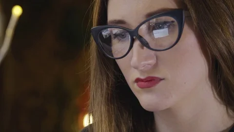 Screen Reflected in Glasses Woman Uses Tablet and search information on Internet Stock Footage