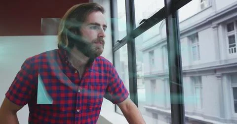Screens with medical data processing against caucasian man looking out of the Stock Photos