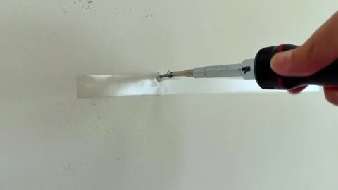 A Screw Being Threaded Into A Drywall Wall Anchor With A Screwdriver Into A Stock Footage 309963509