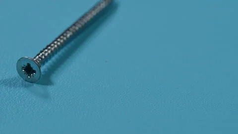 Screw on a blue background Stock Footage 99850599