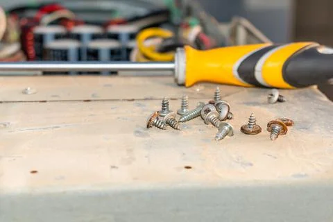 A screw driver and a bunch of rusty screws Stock Photos