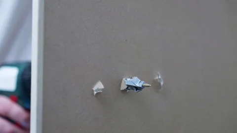Screw fixation with plastic dowel in drywall hole, electric screwdriver Stock Footage 268700617