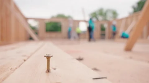 Screw in Foreground with Home Construction Crew Building House Vídeos de archivo 345179140