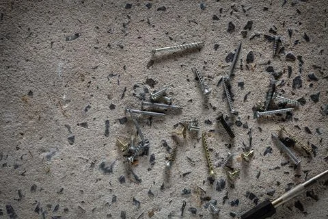 Screw, nail on concrete texture background. Closeup of screws and nails on .. Stock Photos