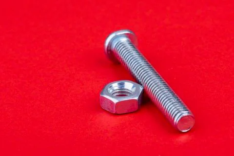 Screw with nut single on red background Stock Photos
