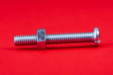 Screw with nut single on red background Stock Photos