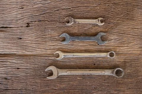 Screw nuts and wrenches frame, on color wooden background Foto stock