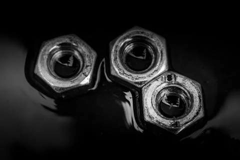 Screw-nuts in water, close up image, background Stock Photos