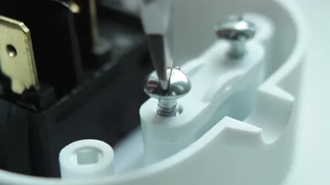 Screw in into a part of a plastic electrical appliance with a screwdriver Stock Footage 146775720