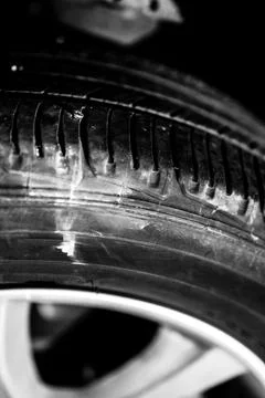 Screw protruding from the tread of a tire causing a flat. Stock Photos