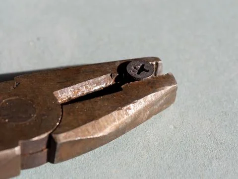 The screw is pulled out of the drywall with old pliers Stock Photos