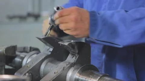 Screw thread cutting. A man cuts a screw thread in a metal part. Working with a Video stock 151511891