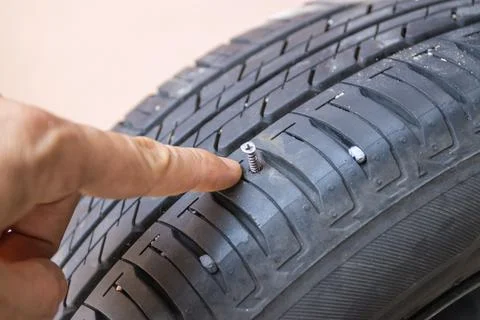 Screw in tyre stuck inside it, concept checked and removing Stock Photos