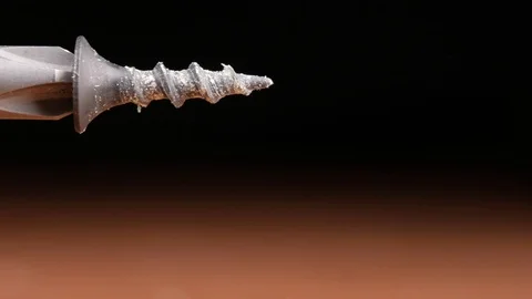 The screw is wearing a bit of electric screwdriver. Macro photography moving Stock Footage 73396631
