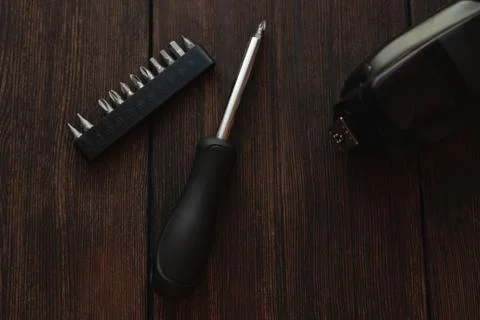 Screwdriver and electronic device on dark wooden background Stock Photos