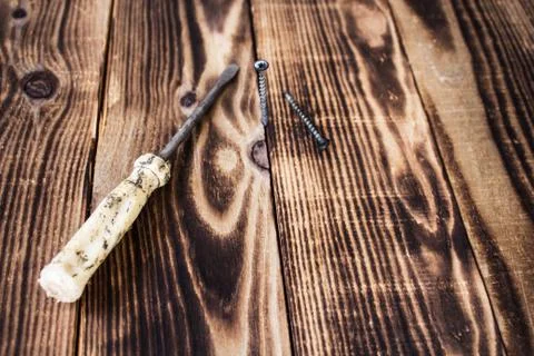 Screwdriver and screw on eooden background Stock Photos